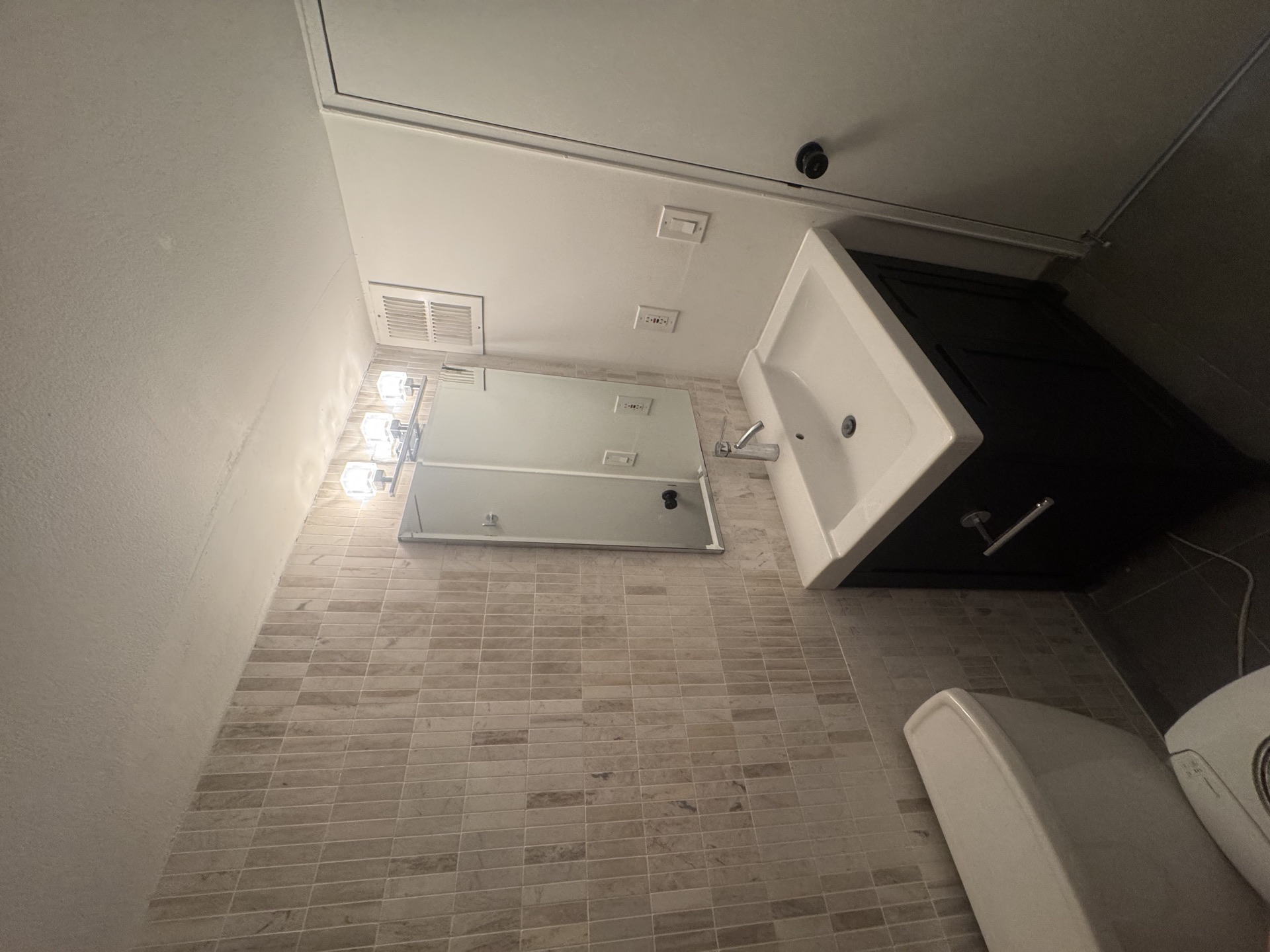 Small bathroom with mosaic tile floor, pedestal sink, dark vanity, and toilet