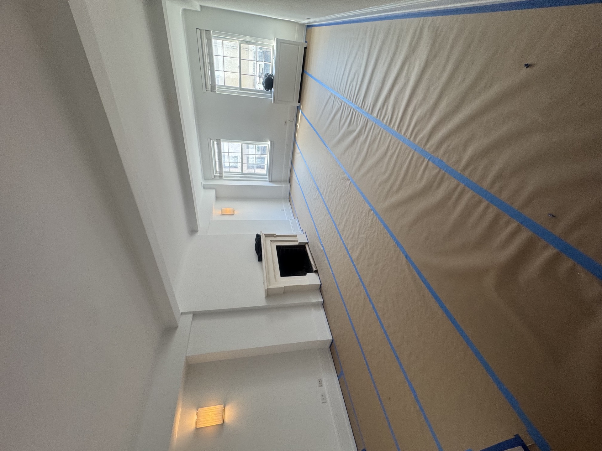 Painted stair area with tall windows and papered walls