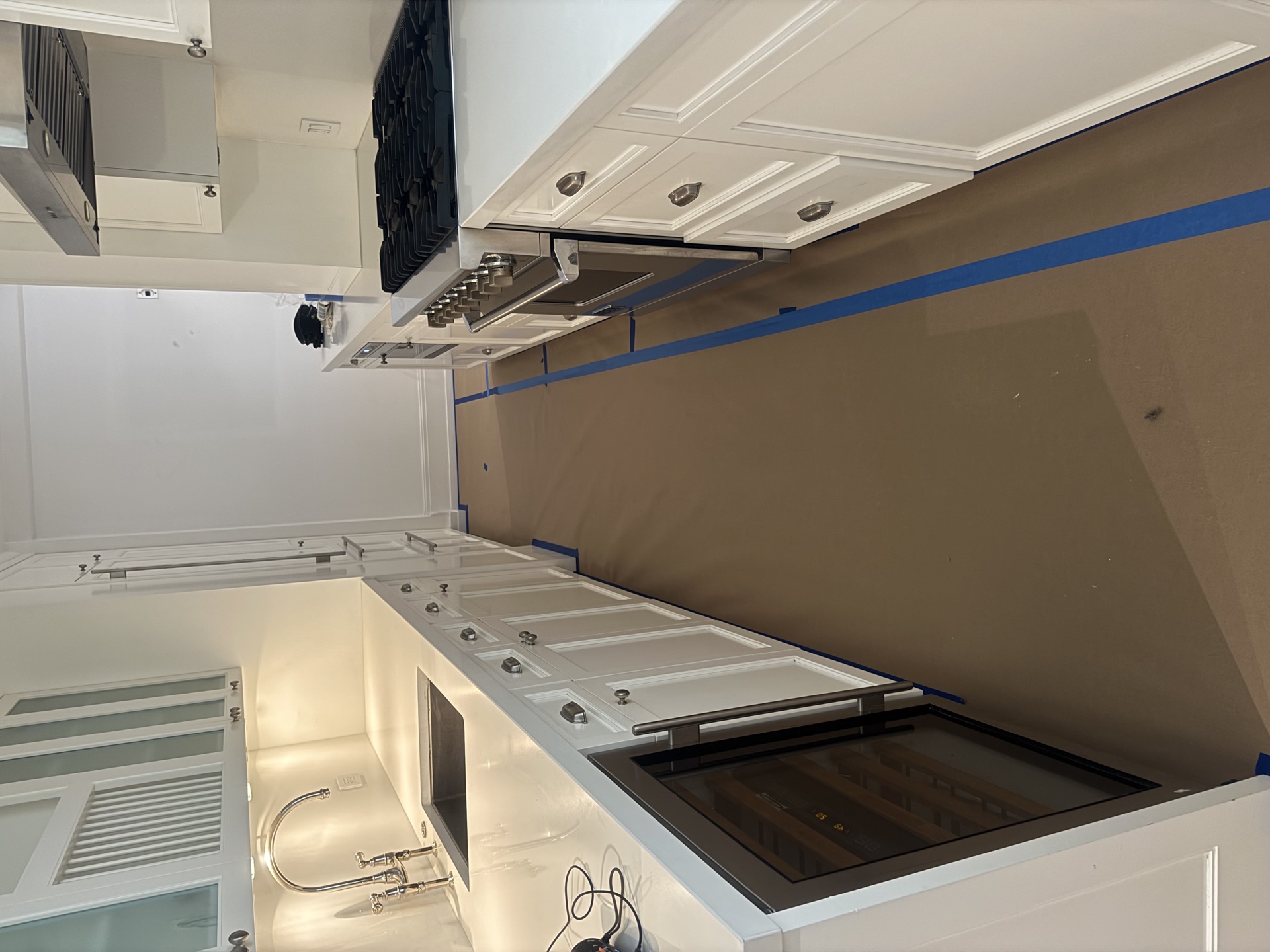 Gas cooktop, stainless hood, and glossy white cabinets, ready to cook
