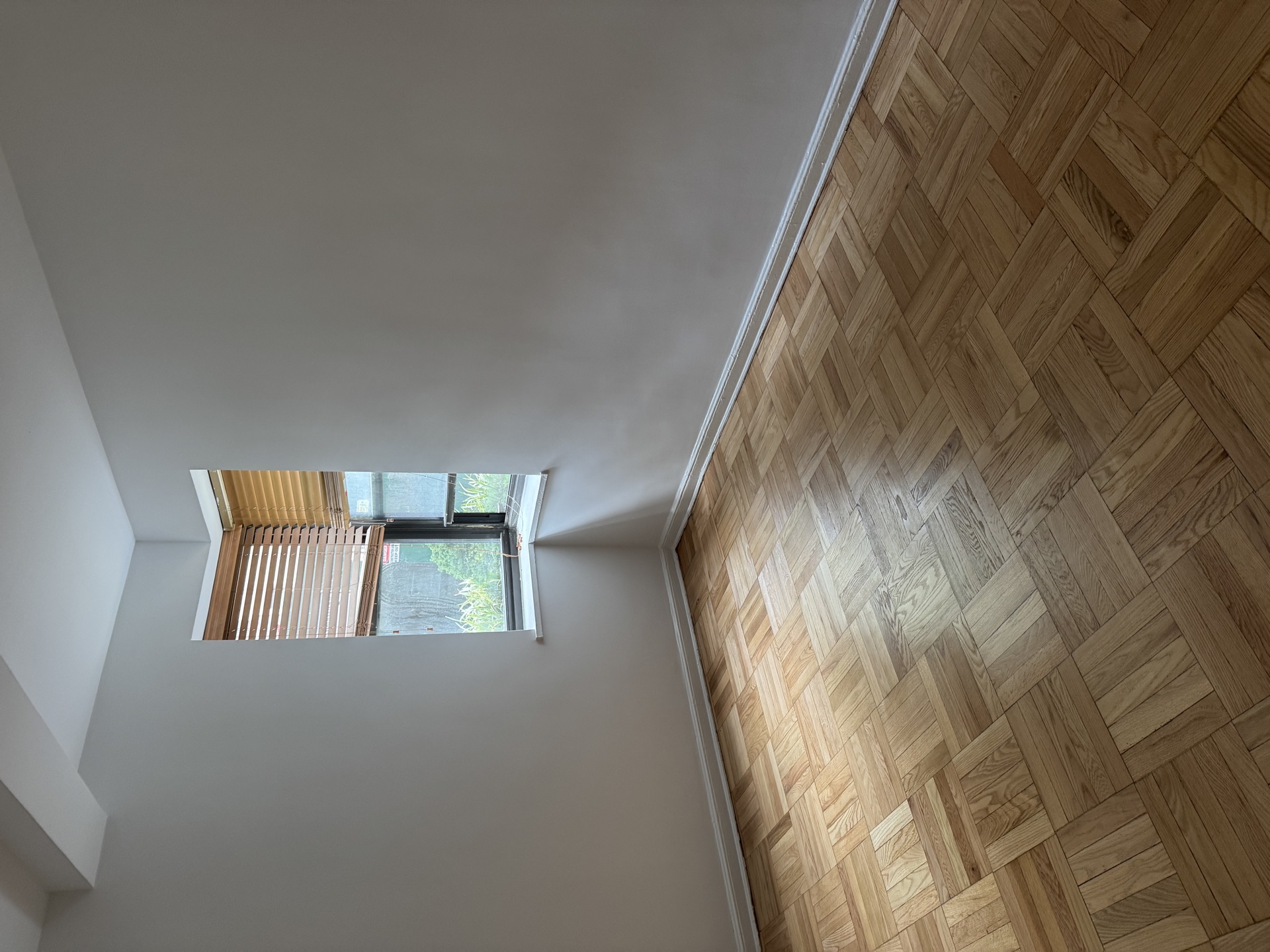 Newly installed parquet hardwood in a bright white room